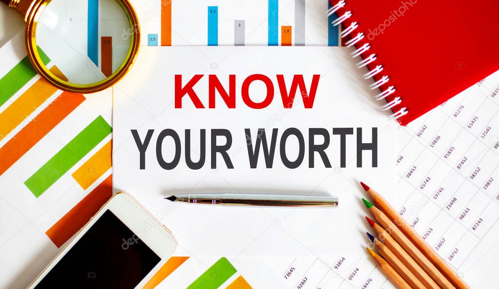 Text Know Your Worth on notepad with office tools, pen on the financial report
