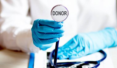 Metin DONOR sağlık konseptiyle steteskop tutan kadın.