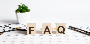 Tahta küplerdeki FAQS metni kalem ve gözlüklerle.