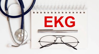 Stetoskop, gözlük ve kalemle beyaz arka planda metni EKG olan.