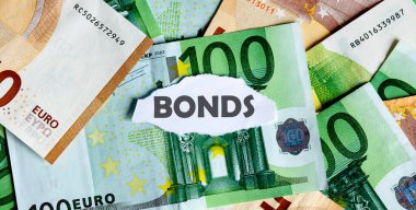 Arka planda EUROS para birimi olan yırtık beyaz kağıt parçasına BONDS kelimesine odaklanın. İş kavramları.