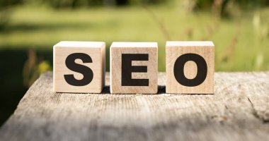 SEO Arama Motoru İyimser metin tahta küpleri ve tahta masa arkasındaki büyüteç. Fikir, Vizyon, Strateji, Analiz, Anahtar Kelime ve İçerik kavramı