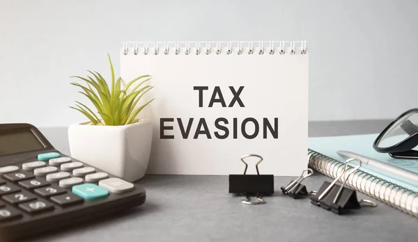 Tax Evasion text on sticky notes isolated on office desk