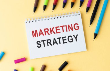 Not defterinde pazarlama stratejisi metni ve masada kahve