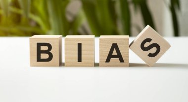 BIAS kelimesi, beyaz bir arkaplan üzerinde ahşap harflerle yazılıyor..