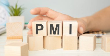 Tabloda altın külçesi ve gazete olan ahşap küp üzerine PMI metni, ekonomik veri kavramı