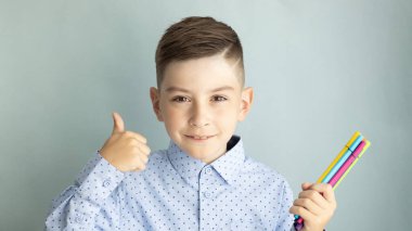 Okula dönelim. Mutlu gülümseyen çocuk. İlkokuldan üniformalı bir çocuk. Komik çocuk.