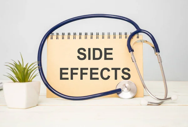 Side Effect word with stethoscope and pen on wooden background as medical concept