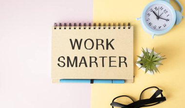 Çalışma SMARTER bir bilgisayar, çiçek, bardaklar, büyüteç ve kağıt ataçlar yakın bir arkaplan üzerine yazılmış