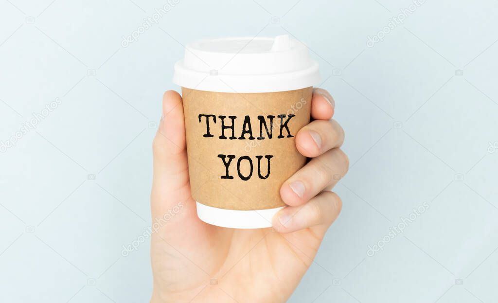 thank you or thank you concept with a cup of coffee in hands on a light background.