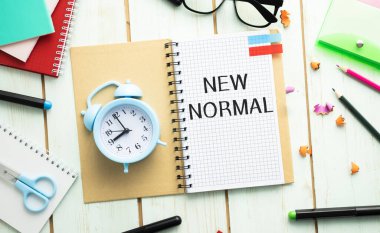 COVID 19 koronavirüsünden etkilenen yeni normal konsept, yaşam tarzımızı değiştirip, ofis masasında yazılan not defterinde anormalliğin yeni normal haline gelmesiyle ortaya çıkan yeni bir normal konsept. .