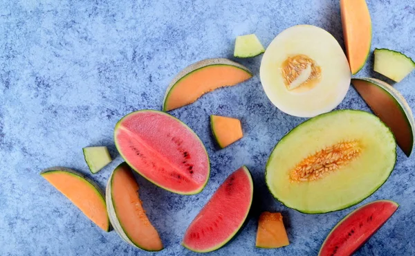 Frisch Geschnittene Melonen Und Wassermelonen Auf Blauem Steinhintergrund Kopierraum Und — Stockfoto