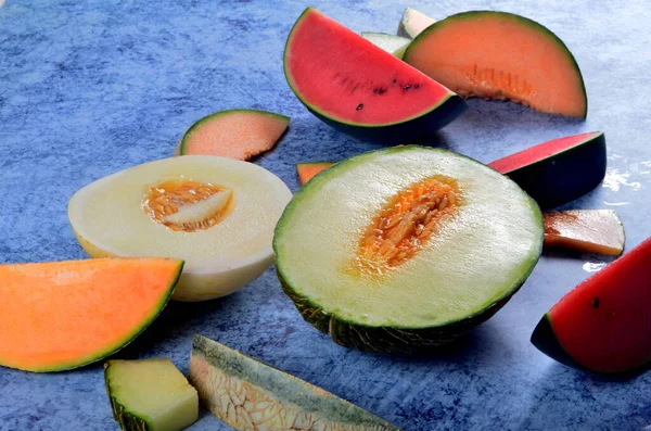 Frisch Geschnittene Melonen Und Wassermelonen Auf Blauem Steinhintergrund Kopierraum Und — Stockfoto