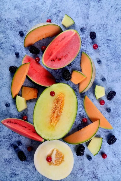 Frisch Geschnittene Melonen Wassermelonen Und Beeren Auf Blauem Steinhintergrund — Stockfoto