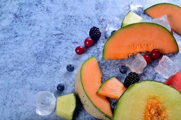 Fresh Cut Melon Watermelon Berries Ice Cubes Blue Stone Background — Stock Photo, Image