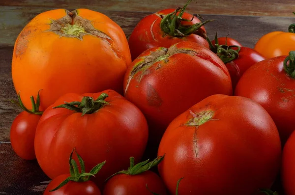 暗い素朴な背景に熟した有機トマトを豊富 カラフルなトマト — ストック写真