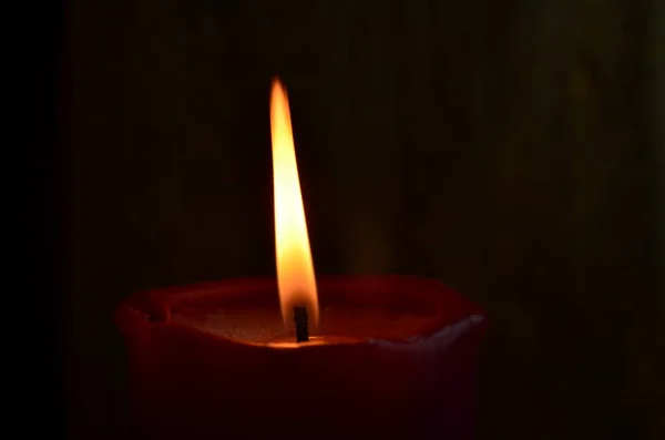 暗い背景に炎を踊りながら 単一の赤いキャンドルを燃焼 — ストック写真
