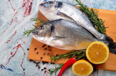 Limonlu, soğanlı ve biberiyeli iki taze Dorado balığı.