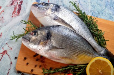 Limonlu, soğanlı ve biberiyeli iki taze Dorado balığı.