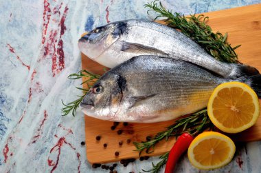 Limonlu, soğanlı ve biberiyeli iki taze Dorado balığı.