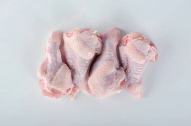 Beyaz arka planda dört çiğ tavuk kanadı. Taze çiğ tavuk kanadı..