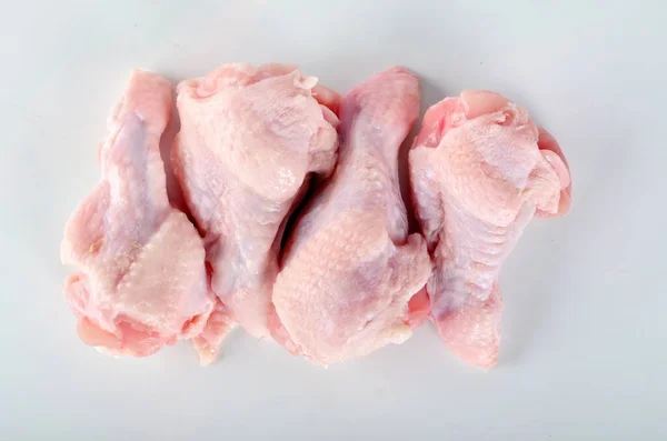 Four raw chicken wings isolated on white background. Fresh raw drumstick of chicken wings.