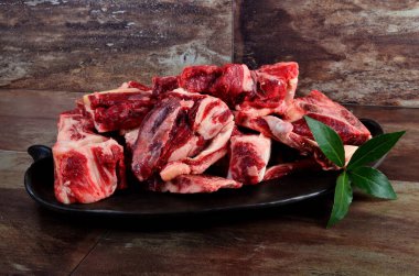 Kil plakalı çiğ et ve kahverengi taş arka plan. Sığır kemikli çiğ et. Çorba için sığır kemiği seçimi