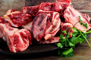 Kil plakalı çiğ et ve kahverengi taş arka plan. Sığır kemikli çiğ et. Çorba için sığır kemiği seçimi