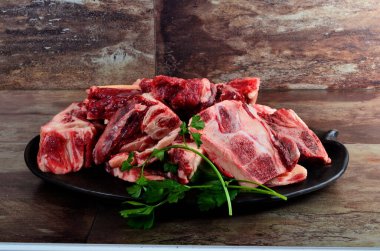 Kil plakalı çiğ et ve kahverengi taş arka plan. Sığır kemikli çiğ et. Çorba için sığır kemiği seçimi