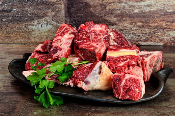 Kil plakalı çiğ et ve kahverengi taş arka plan. Sığır kemikli çiğ et. Çorba için sığır kemiği seçimi