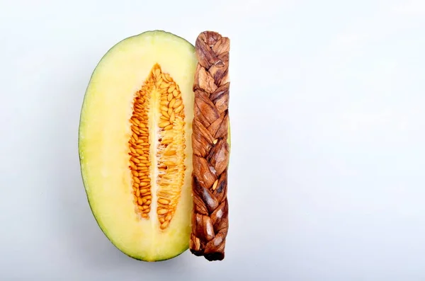 Dried melon in the form of plait on cut melons isolated on white background, dried fruits. Braided Dried Melon