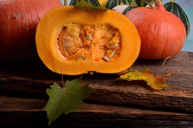 Tahta arka planda yarım portakallı balkabağı kes