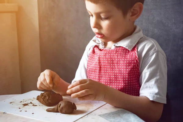 Çamurdan yapılmış şirin bebek heykelleri. El işi, çömlek, çocuk sanatı, eğitim, evde oynamak. Ilık ışık, seçici odak resim ve gürültü efektleri.
