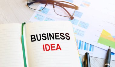 Ofis işyerinde, arkaplanda bir not defteri ve ahşap bir masanın üzerinde iş grafikleri var. İş konsepti çalışma alanı.