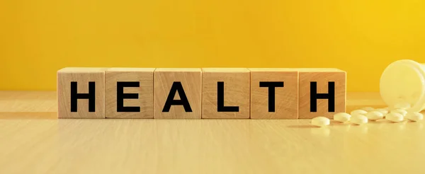 木製のキューブ 明るい黄色の背景に碑文の健康 健康と医療の概念 — ストック写真