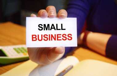 Kartviziti elinde tutan bir iş kadını. Yazıtın içeriği iş konsepti ve pazarlama açısından önemlidir..