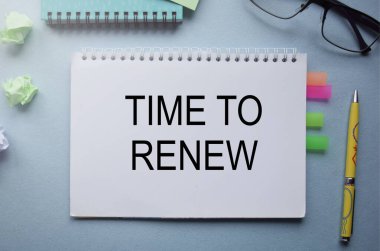 Yenileme zamanı geldi. Finans tablolarının arka planında el yazısıyla yazılmış bir metin.