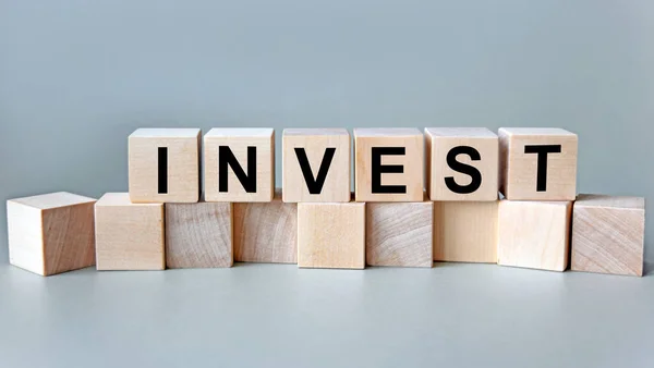 Iscrizione Invest Cubi Legno Isolati Uno Sfondo Chiaro Concetto Business — Foto Stock