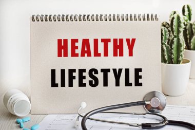 Masanın üzerinde haplar, stetoskop, kardiyogram ve 