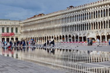 Venedik, İtalya - 23 Eylül 2015: Venedik, İtalya 'daki Piazza San Marco' da seller boyunca yürüyen turistler