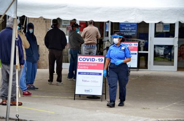 Scarborough, Ontario, Canada, June 2, 2020: People wait in line for a Covid-19 test at the pop-up mobile Assessment Centre at 1250 Markham Road in Scarborough, Ontario. clipart