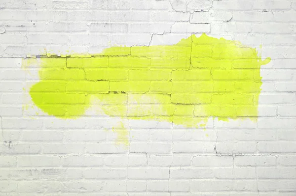 Pintura amarilla o graffiti en pared de ladrillo blanco — Foto de Stock