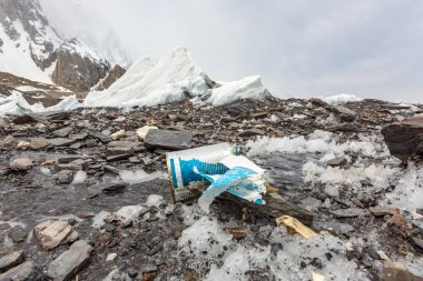 Çöpler karlı dağın üzerine dağıldı. Gezegeni kurtaralım ve fazla çöpleri geri dönüştürelim. Kirlilik Kavramı