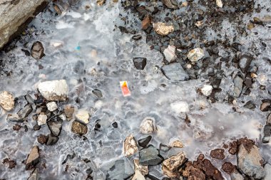 Çöpler karlı dağın üzerine dağıldı. Gezegeni kurtaralım ve fazla çöpleri geri dönüştürelim. Kirlilik Kavramı