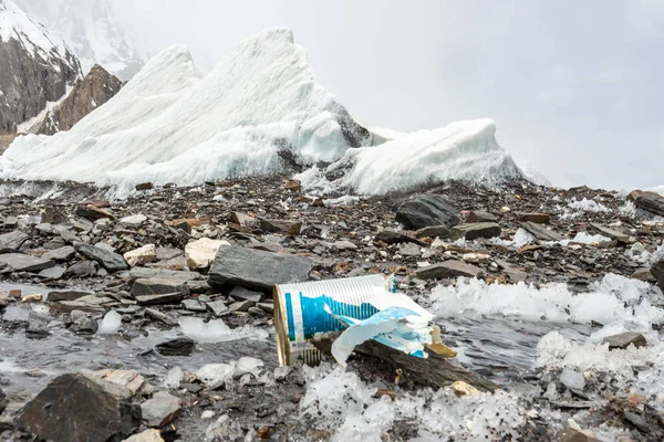 Garbage scattered over snowy mountain. Let\'s save the planet and recycle the excess garbage. Pollution Concept