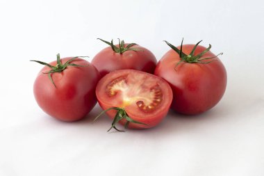 Beyaz zemin üzerine yeşil şube ile kırmızı lezzetli, ağız sulandıran domates