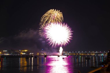 Havai fişek patlamaları renkli sarı ve mor fireballs havai fişek şeklinde şehir bugün Kostroma içinde parlak parlama ile Volga Nehri üzerinde