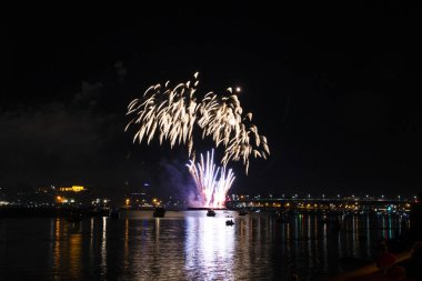 Gece gökyüzü arka plan üzerinde sarı püsküllü ve Volga Nehri üzerinde uzun bir parlama ile fireworks uygulamasından Kostroma gün festival selam