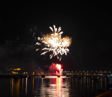 Sarı püsküllü ve gece gökyüzü arka plan üzerinde iğneler ve Volga Nehri üzerinde uzun bir parlama ile Kostroma havai fişek gün festival selam