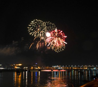 Sarı püsküllü ve gece gökyüzü arka plan üzerinde iğneler ve Volga Nehri üzerinde uzun bir parlama ile Kostroma havai fişek gün festival selam